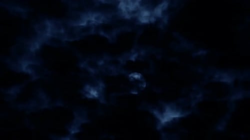 Full Moon Shines Through Clouds at Night