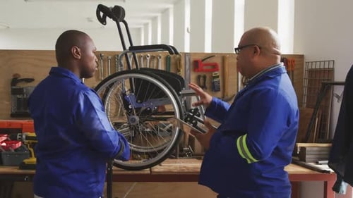 Wheelchair Repair Inspection by Two Uniformed Technicians