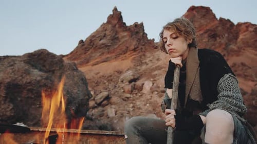 Woman Sitting by Campfire in Post Apocalyptic World