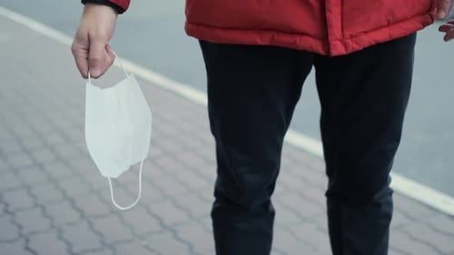 A Man Takes Off His Protective Mask. End of Epidemic, Pandemic. Cure, Healing, Vaccine. Health and