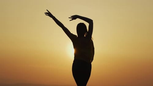 Silhouette of Woman Dancing at Sunset