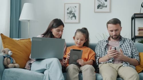 Family Relaxing Together at Home Using Technology
