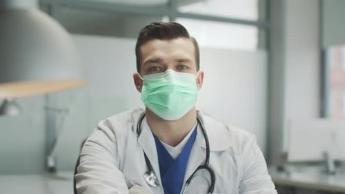 Portrait of a Reliable Authentic Doctor in a Medical Mask in the Hospital Office