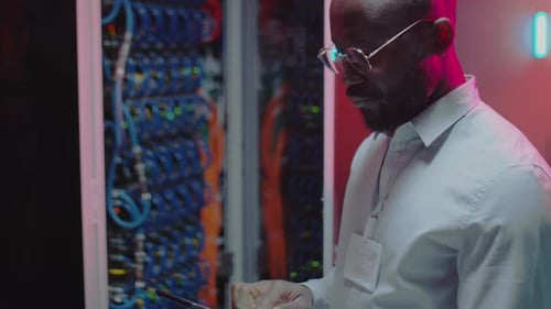 African American Data Center Technician Checking Server