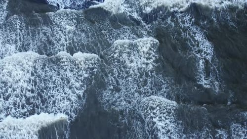 Aerial View of Waves Crashing on Black Beach