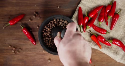 The Man's Hand Stir of Black Pepper in a Mortar