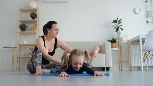 Woman and Girl Exercising at Home Together