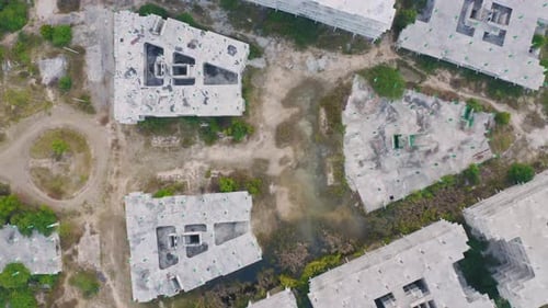 Aerial top view of abandoned apartment or hotel under construction site with structure.