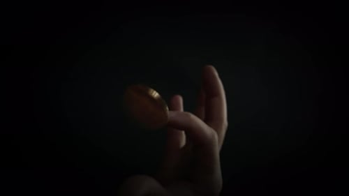 Slowmotion Shot Tossing Bitcoin to Flip on Heads or Tails