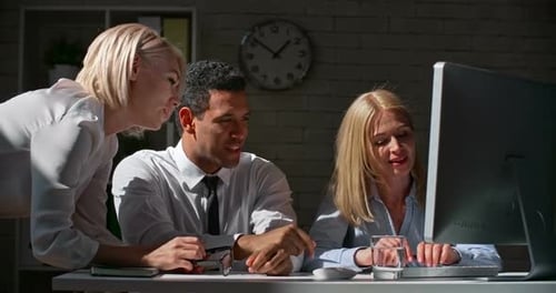 Team Collaboration Around Computer in Bright Office