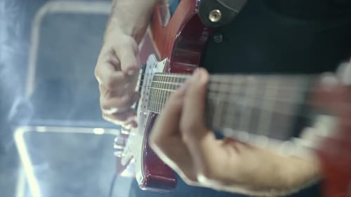 Male Guitarist Playing Electric Bass Guitar on a Rock Concert in a Club