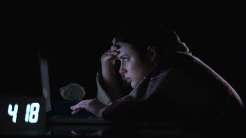 Tired Woman Working on Laptop Late at Night