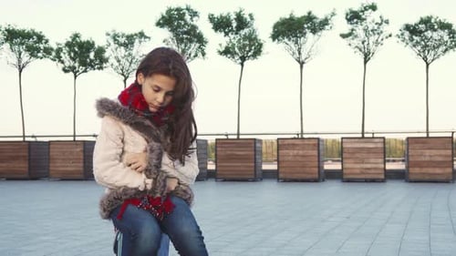 A Sweet Girl Sits in the Middle of the Street and Being Sad