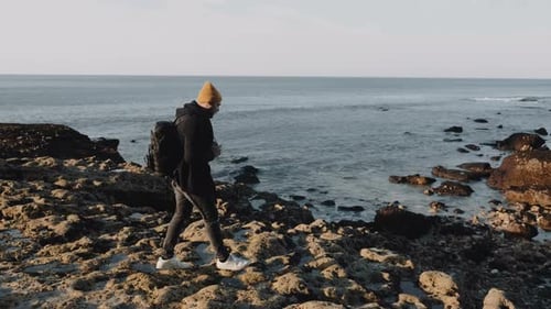 Happy Male Photographer Stepping on Rocky Beach, Taking Pictures of Stunning Sunny Normandy Shore