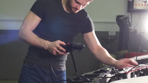 Adult Man Checks the Condition of the Vehicle in a Tire Service Shop