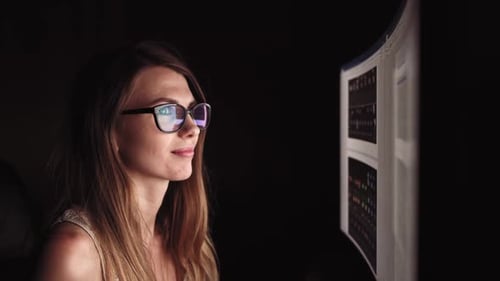 Mujer joven concentrada, sentada en su habitación u oficina. Estudia tarde en la noche