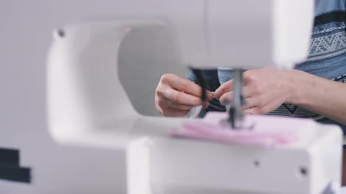Woman Sewing Fabric at Sewing Machine Close Up