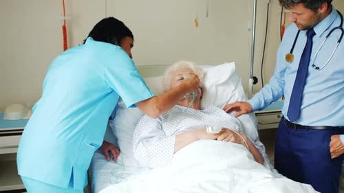 Medical Staff Caring for Senior Patient in Hospital Bed