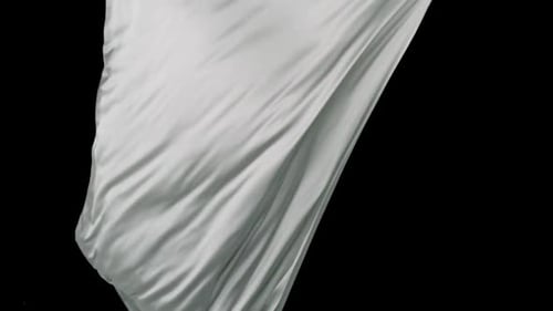 Flowing White Satin Sheet Against Black Background