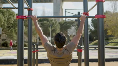 Muscular Man Doing Pullups on Bar Outdoor
