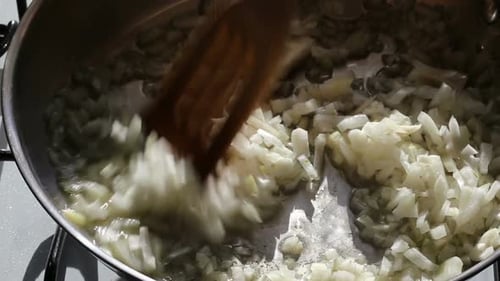 Diced Onions Sautéing in a Metal Pan