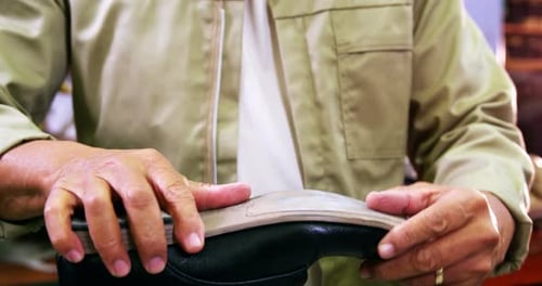 Craftsman Hand-Making a Leather Shoe in Workshop