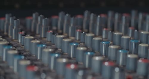 Sound engineer working in a recording studio with a sound console and microphones