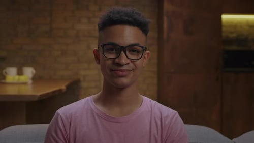 Young Man Bites Into Green Apple Indoors