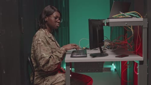 Woman in Camo Outfit Typing on Computer