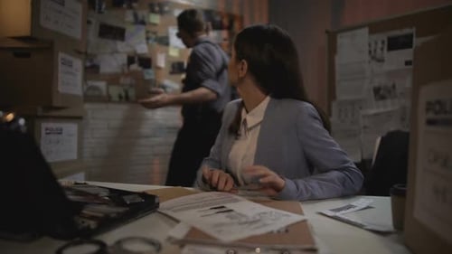 Detectives Researching Criminal Case in Urban Office