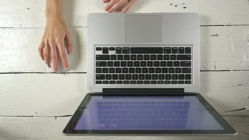 Hands Operating Laptop and Mouse on Desk