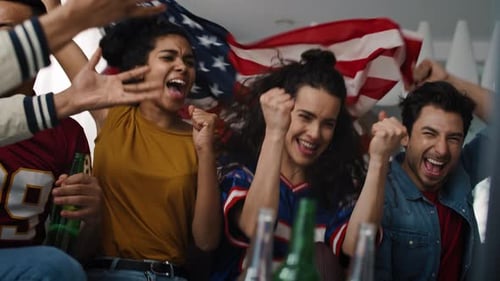 Enthusiastic Young Adults Cheering While Watching a Game