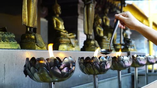 Filling Oil in Buddha Metal Flower Statues