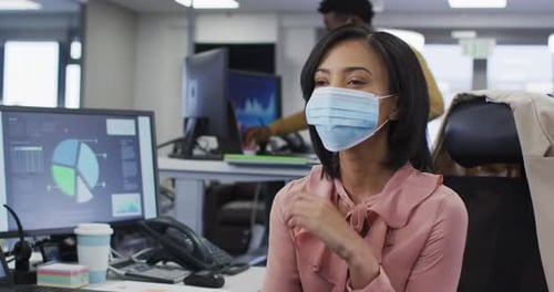 Woman Wearing Mask Thinks at Office Desk