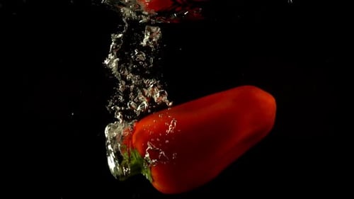 Red Bell Pepper Falling into Water with Bubbles