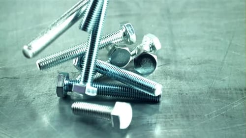 Metal Bolts Falling in Slow Motion on Surface
