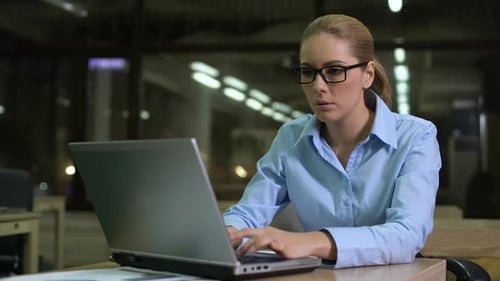 Mujer cansada comprobando el tiempo de guardia, trabajando horas extras en la oficina para cumplir con la fecha límite