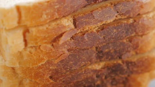 Toast sandwich bread pieces arranged on table 4K 2160p UltraHD tilting footage - Toast bread on wood