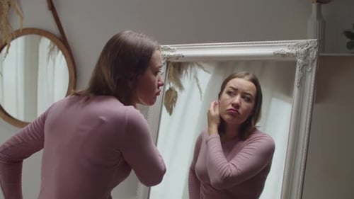 Woman Applying Makeup in Front of Ornate Mirror