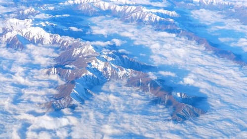 Beautiful View Through Airplane Window, Airplane Flying Above Mountains with Clouds