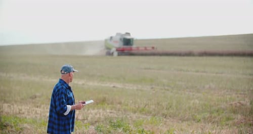 Farmer Using Digital Tablet While Examining Field