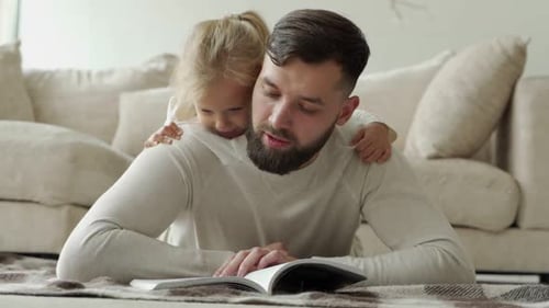 Father Reading to Daughter on Living Room Floor