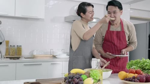 Happy Couple Cooking Salad Together in Kitchen