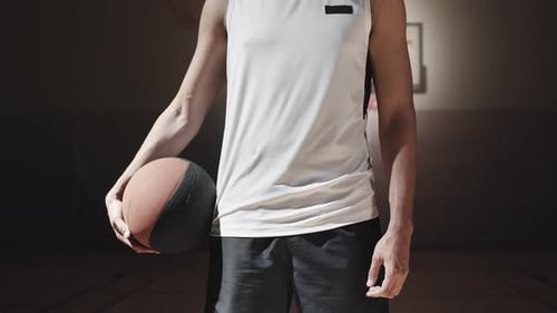 Porträt eines schwarzen Mannes auf einem dunklen Basketballplatz