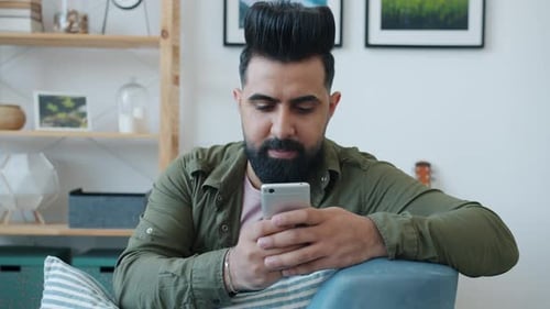 Man Using Smartphone Relaxing Indoors at Home