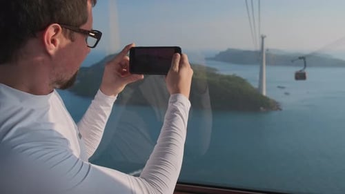 Man Captures Tropical Island View from Cable Car