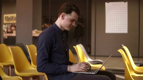 Young Adult Using Laptop in Office Setting