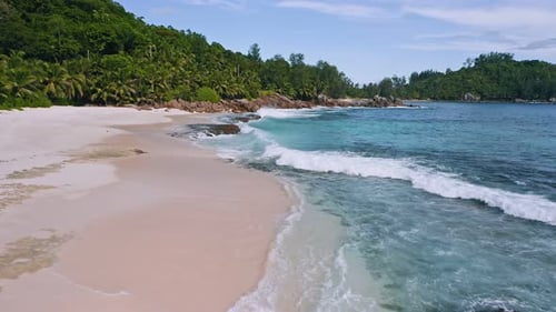 Aerial Low Altitude Fly Above Tropical Sandy Beach with Ocean Waves at Mahe Island Seychelles