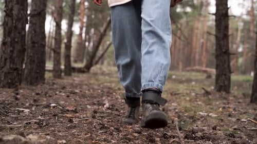 Tourist walks through forest. Closeup tourist legs in dark shoes. Walking hiking travelin