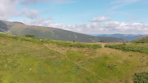 Aerial View of a Traveler with a Backpack Climbing By Mountain Range. Epic Shot